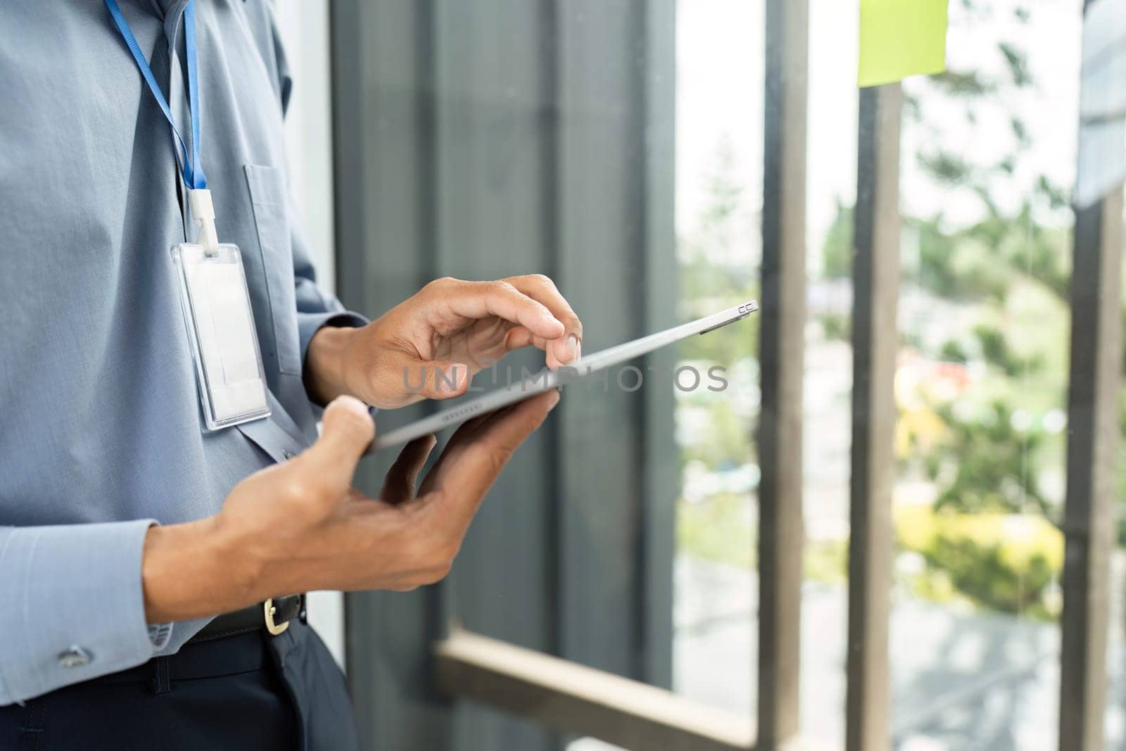 A businessman engages with a tablet, showcasing digital skills in a contemporary office setting, reflecting modern work trends.