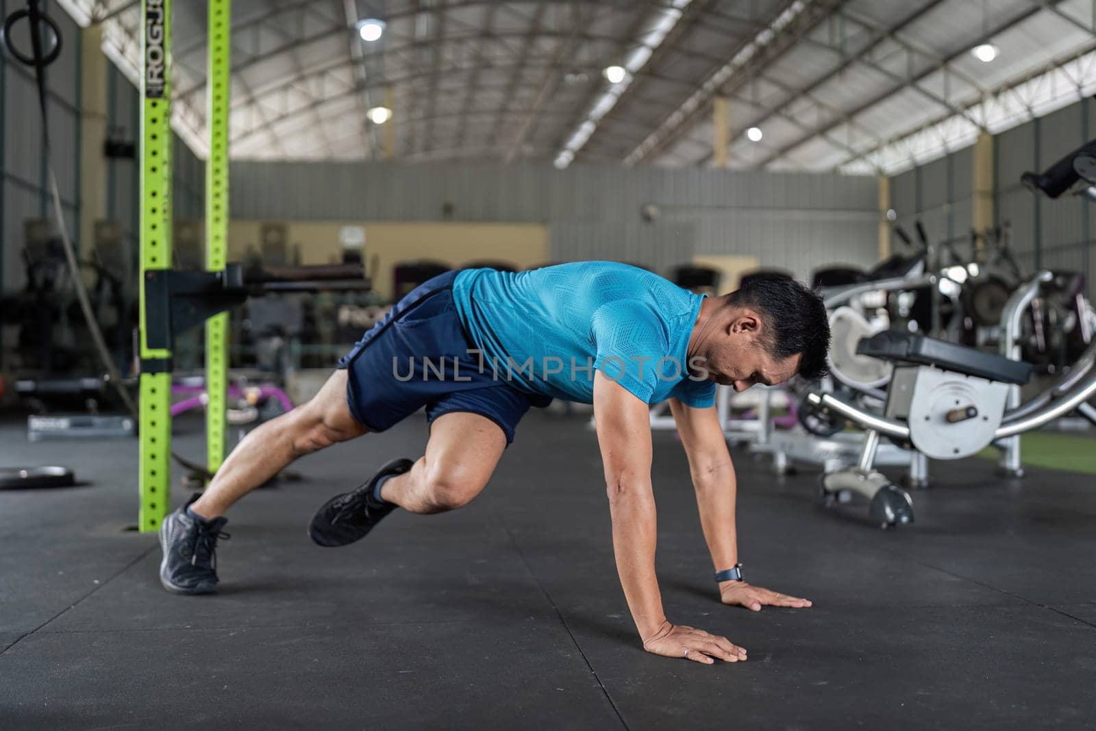 A male athlete engages in mountain climbers, boosting cardiovascular fitness and agility in a workout session.