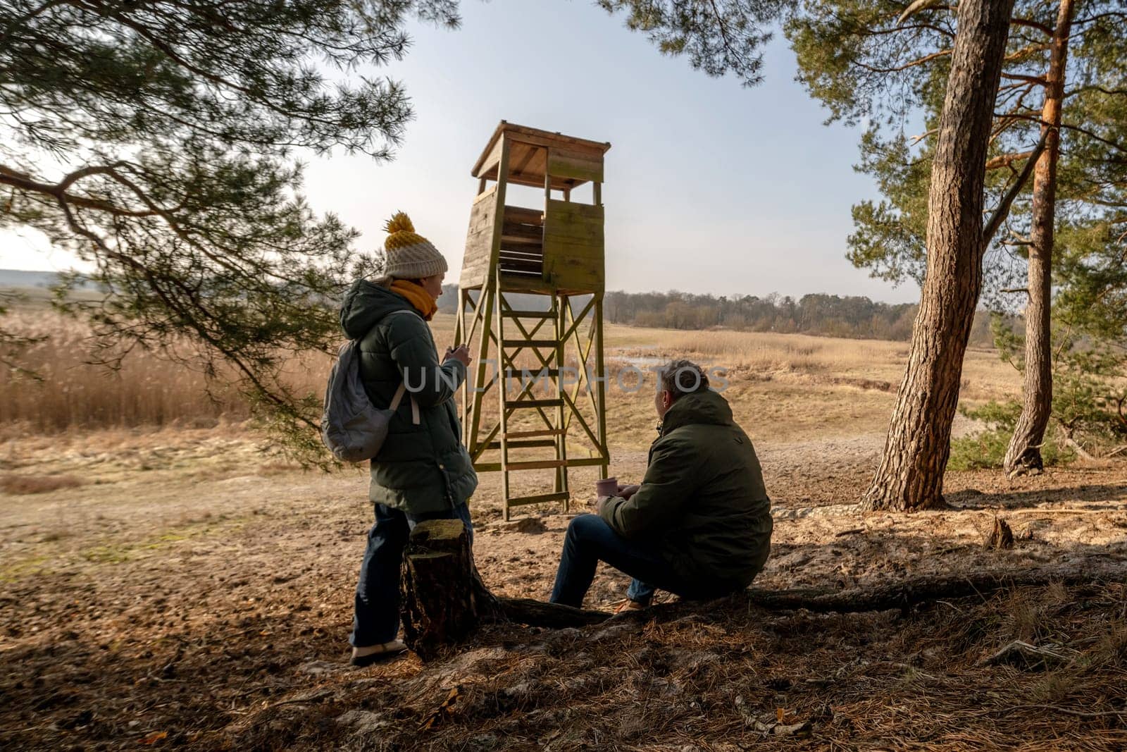 Dad And Daughter Drinking Tea From A Thermos Near The Observation Tower In Spring