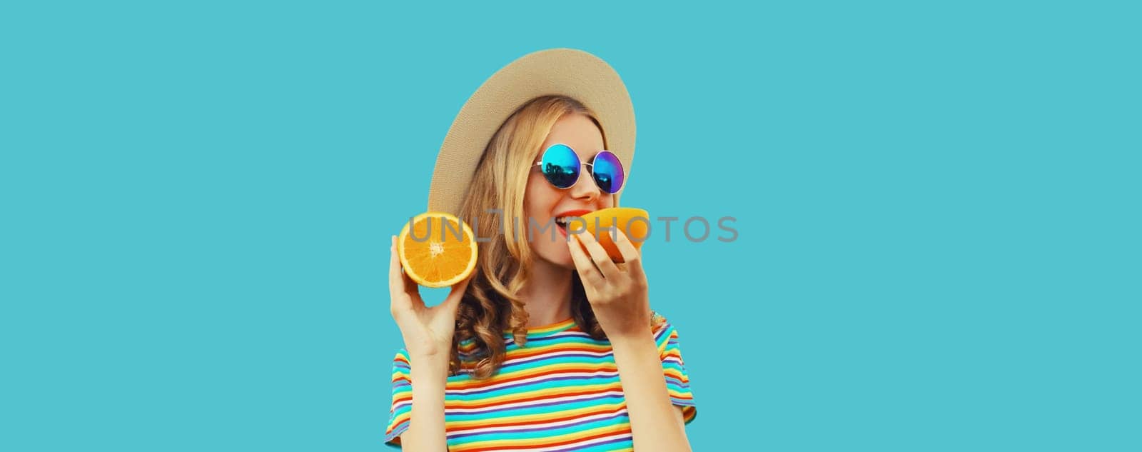 Summer, nutrition, diet and vegetarian concept. Happy healthy cheerful young woman with slices of orange fruits isolated on blue background