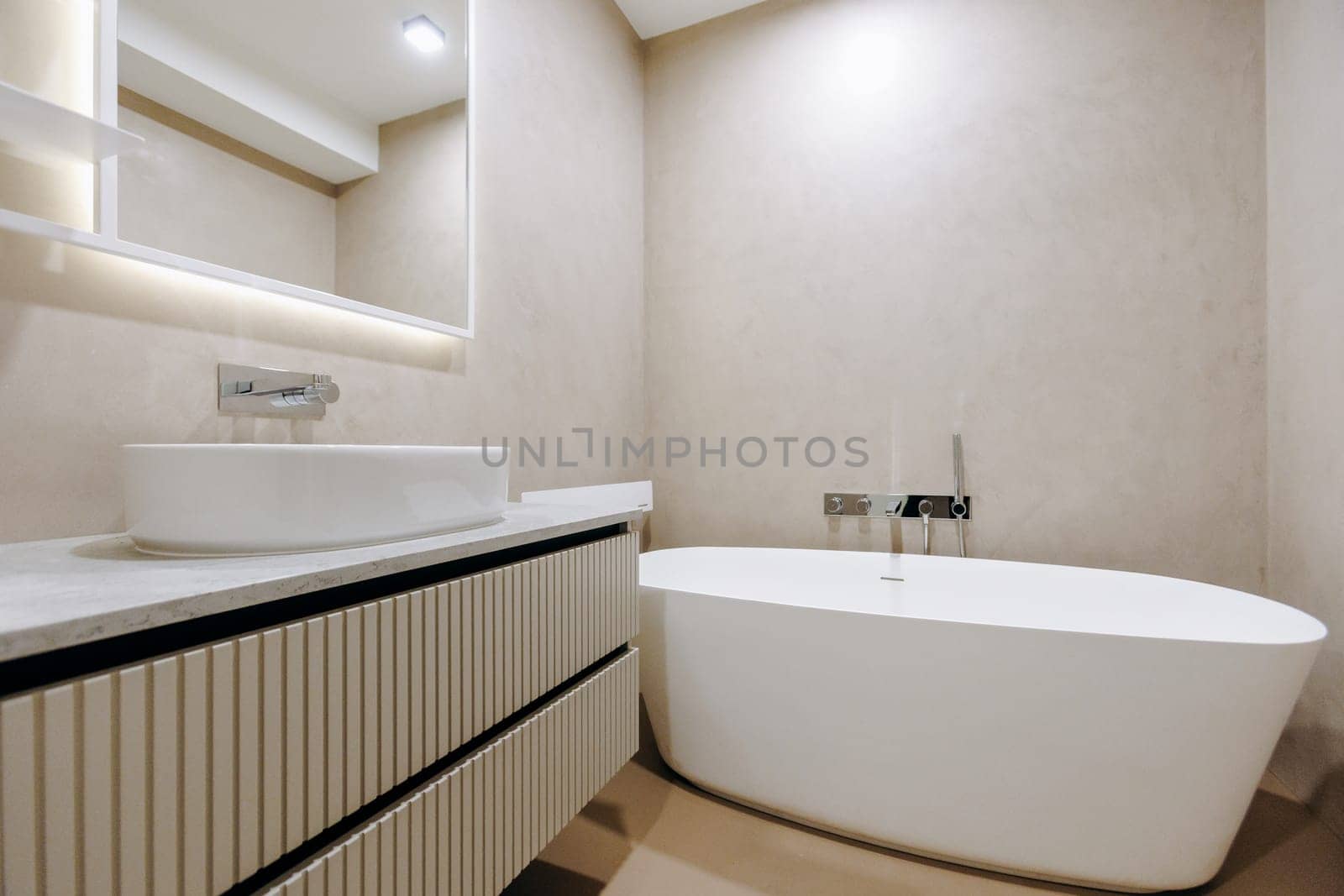 A welldesigned bathroom containing essential features such as a nice bathtub, a sink, and a wall mirror for convenience and style