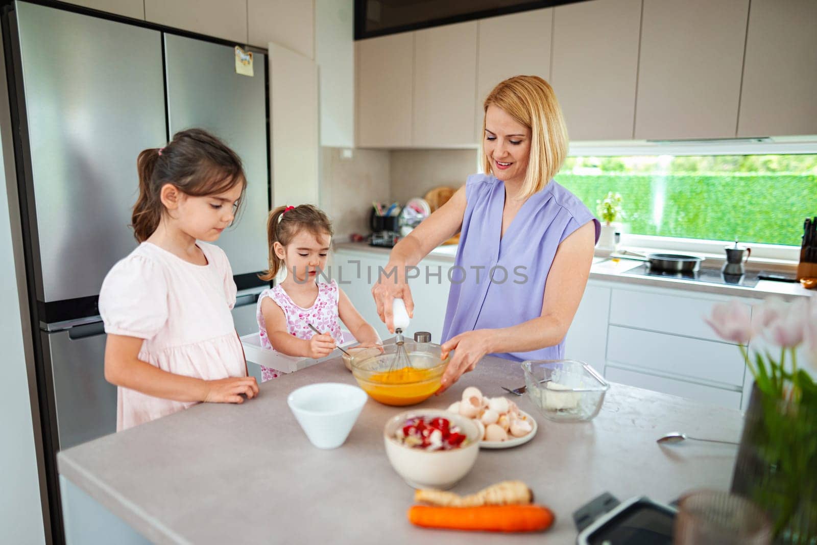 Family fun unfolds as children help mix ingredients joyfully.