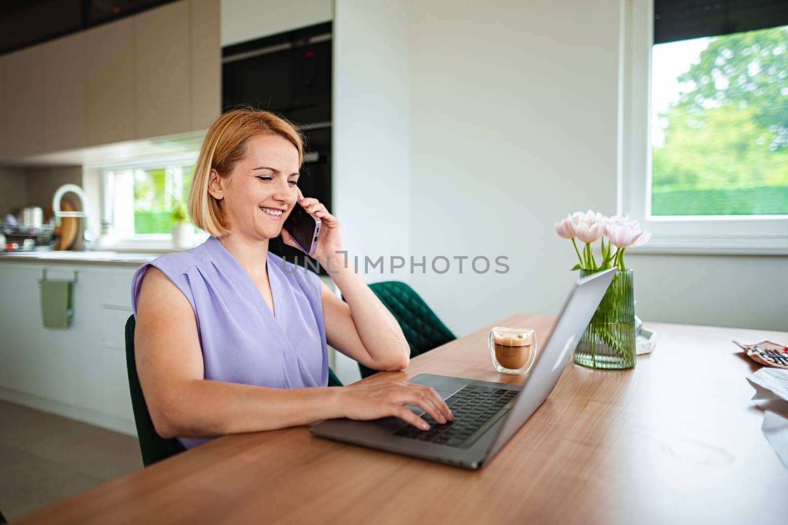 Focused professional engages in conversation while typing.