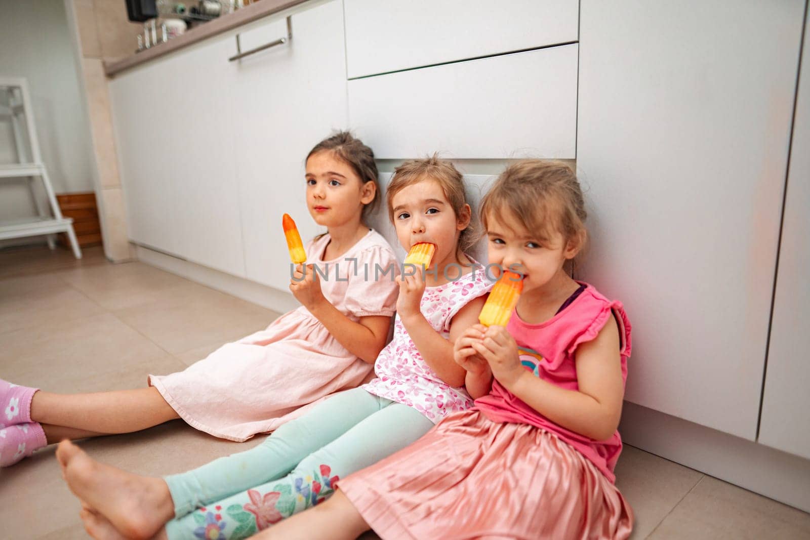 Little friends savoring refreshing ice pops on a warm day