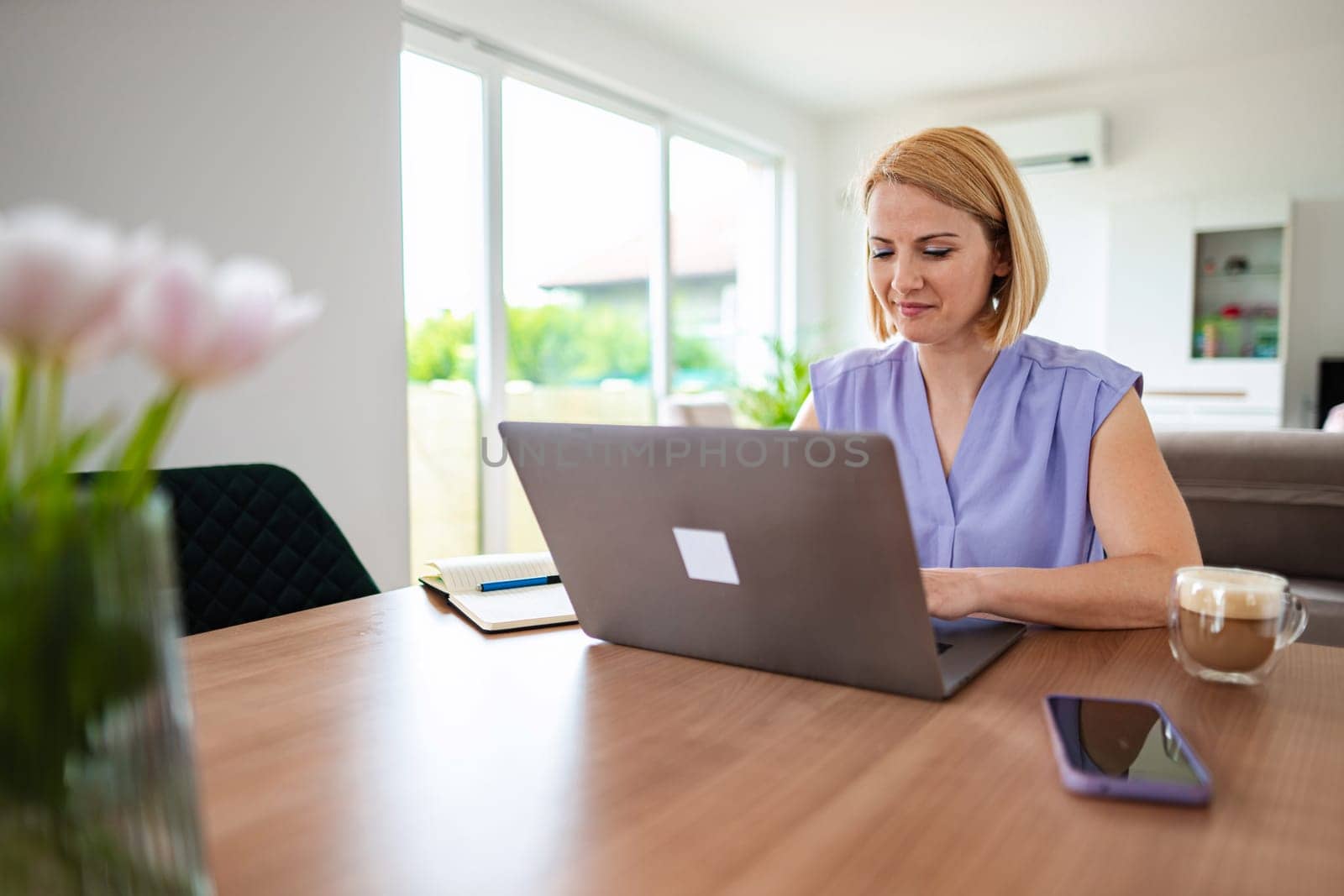 Professional woman focused on tasks at wooden table