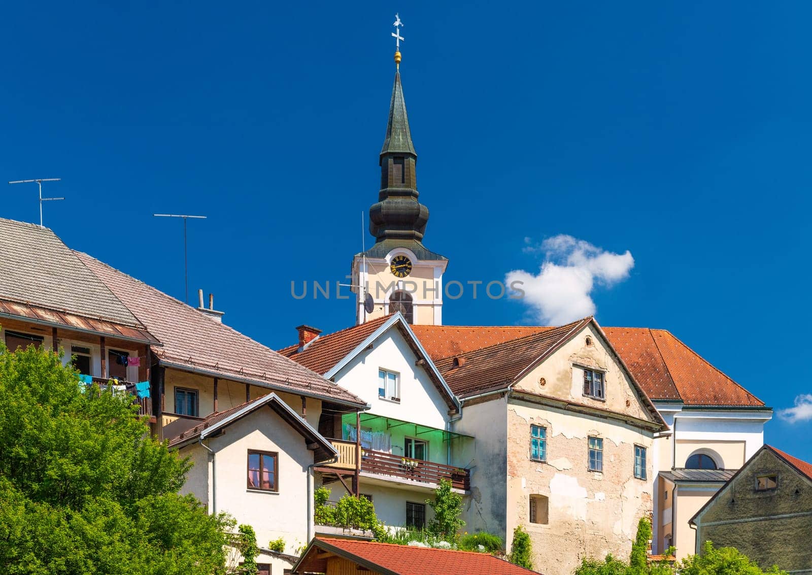 View of old residential houses in front of the Parish Church of St. Nicholas in Metlika, Slovenia.