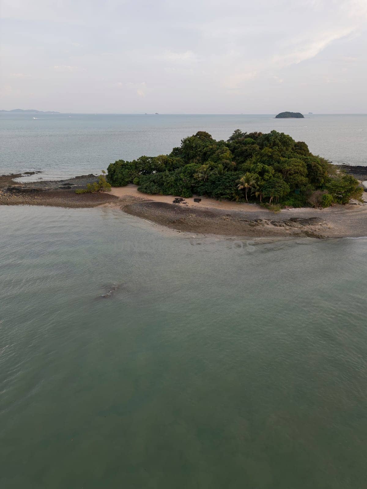 Aerial view of a majestic small Thai island with sailboats around the shore, amazing travel destination featuring crystal clear waters and dense rainforests. Tropical landscape.