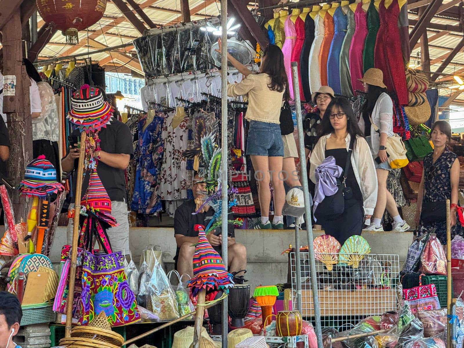 Bangkok, Thailand - November 12, 2024: Famous floating market with boats selling food, bustling local bazaar where vendors sell Thai seafood or traditional goods. Authentic cultural experience.