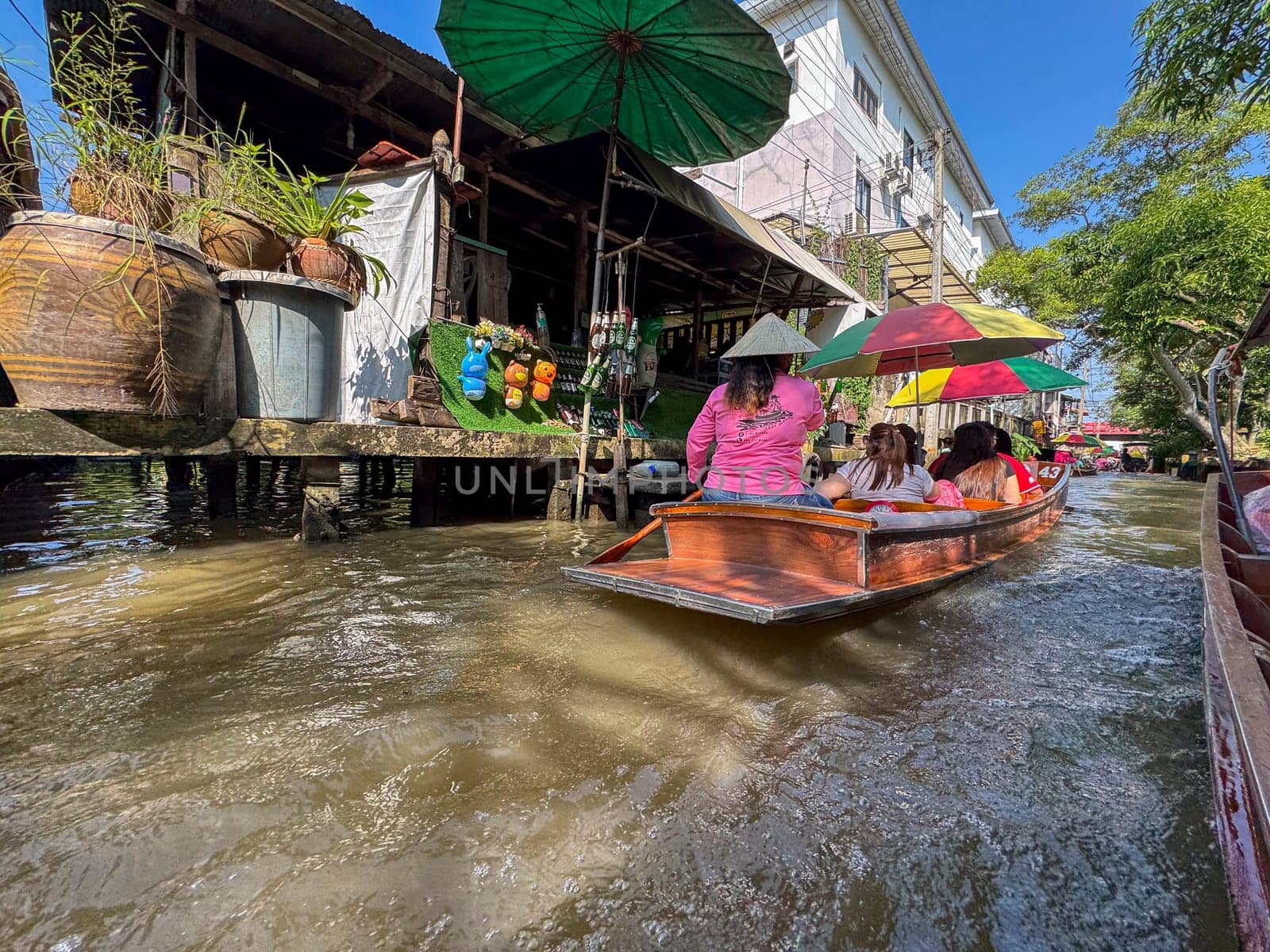 Bangkok, Thailand - November 12, 2024: Traditional floating market in boats of produce, market vendors sell Thai food, fruits and seafood from boats. Thailand culture and tropical bazaar.