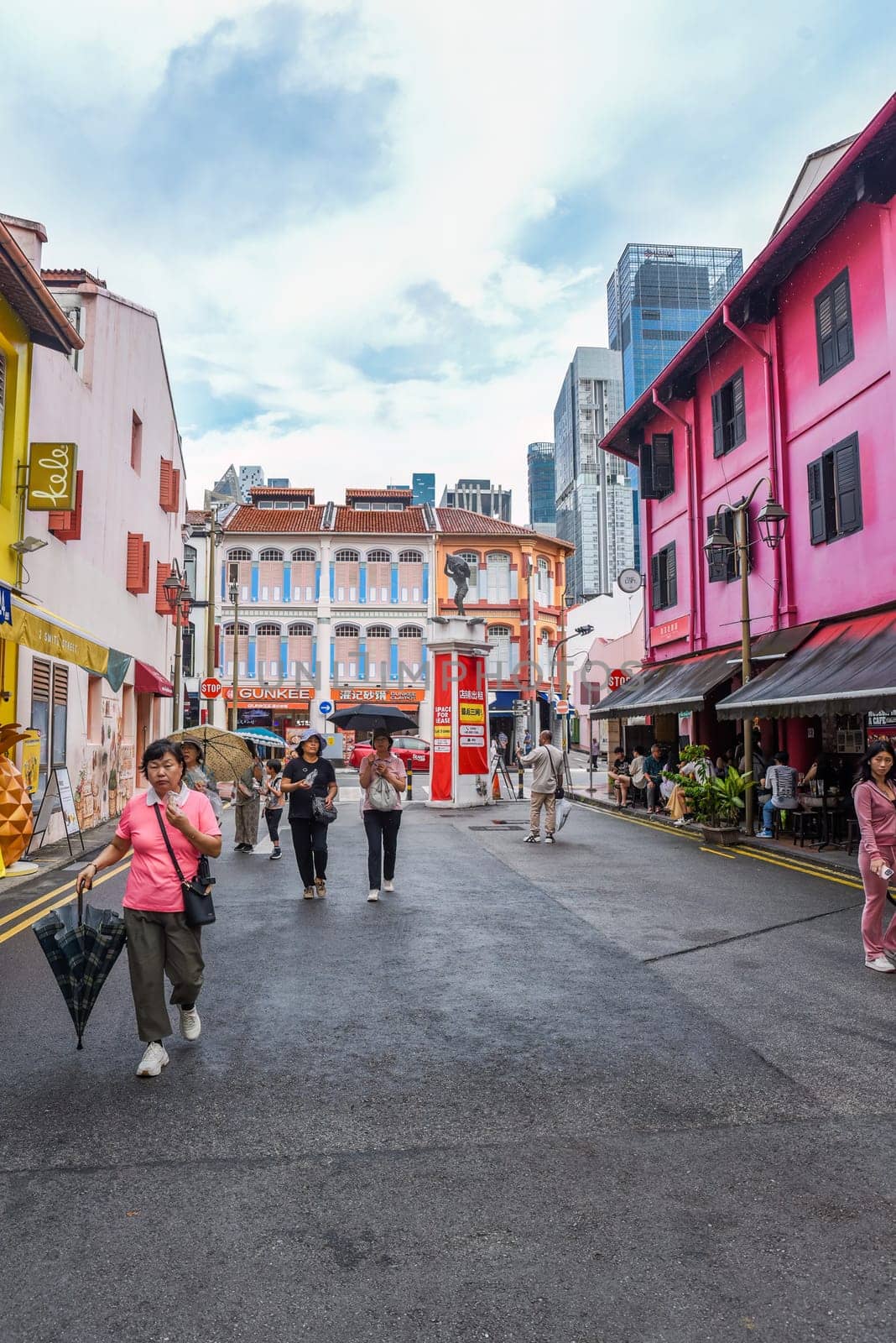 Singapore, Singapore - 4 April 2025: Vertical view of Little India street with colorful colonial buildings and high-rise hotels in the background