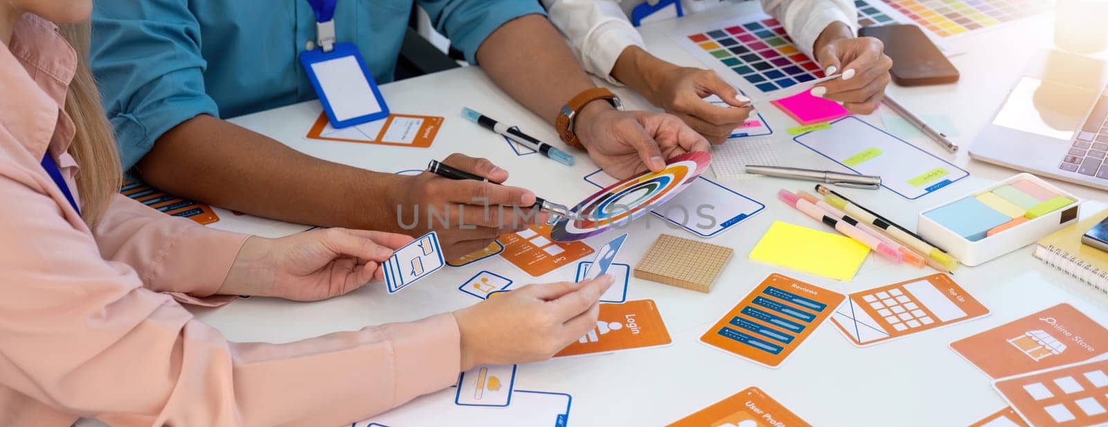 Professionals collaborating on UI UX prototypes and color schemes, enhancing user experience through teamwork and creativity.