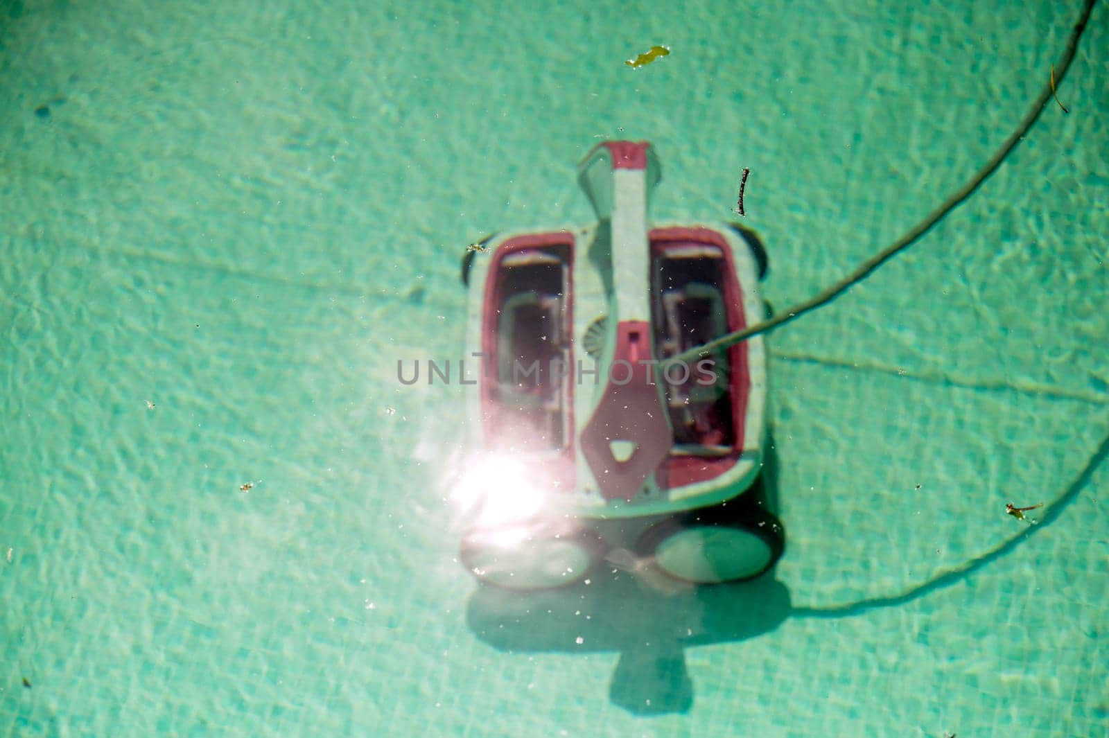 Automatic robotic pool vacuum cleaner under water cleaning the floor. view through water. High quality photo