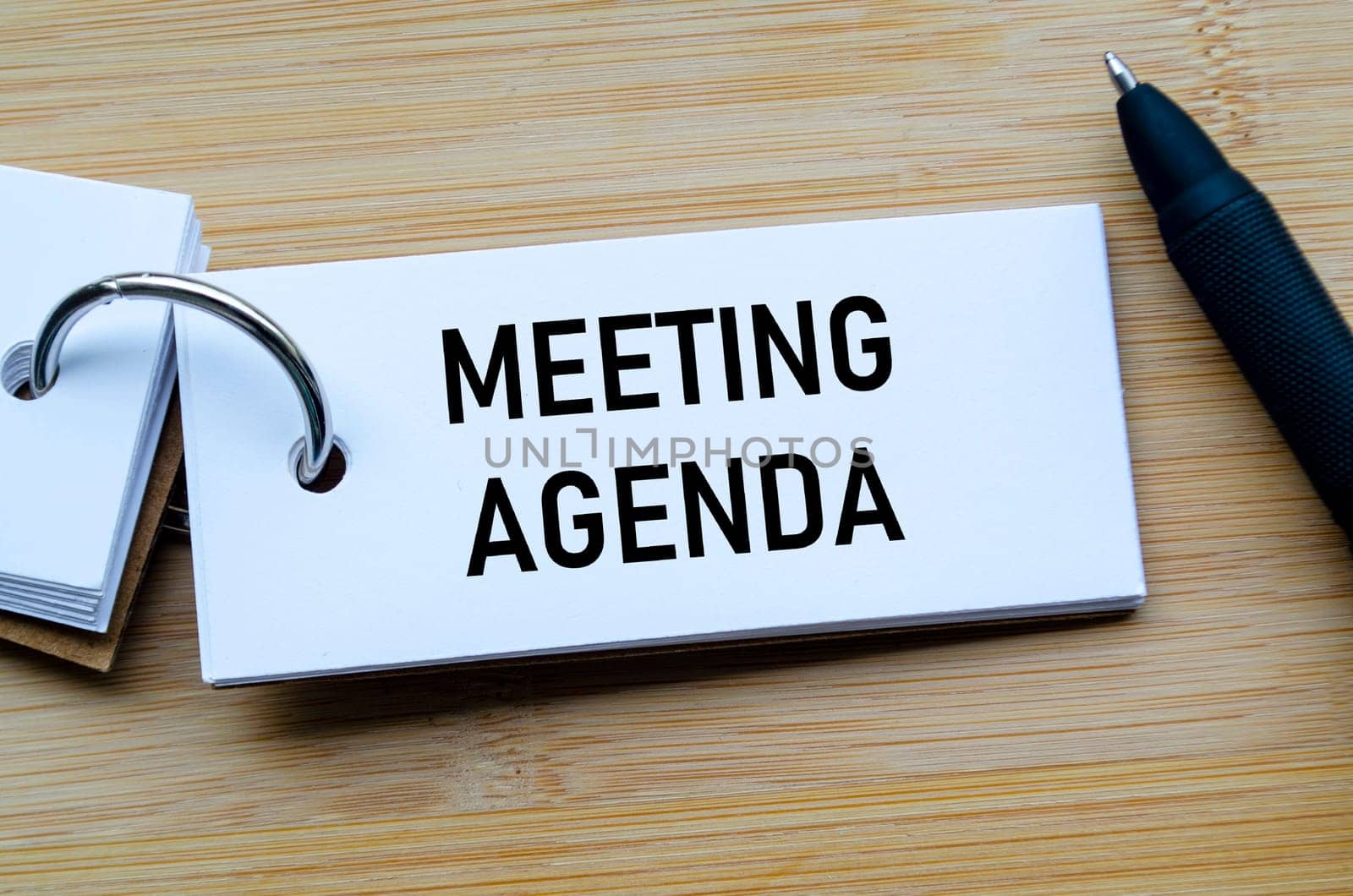 Meeting Agenda text on notepad illustrating structured planning and organized discussion points.