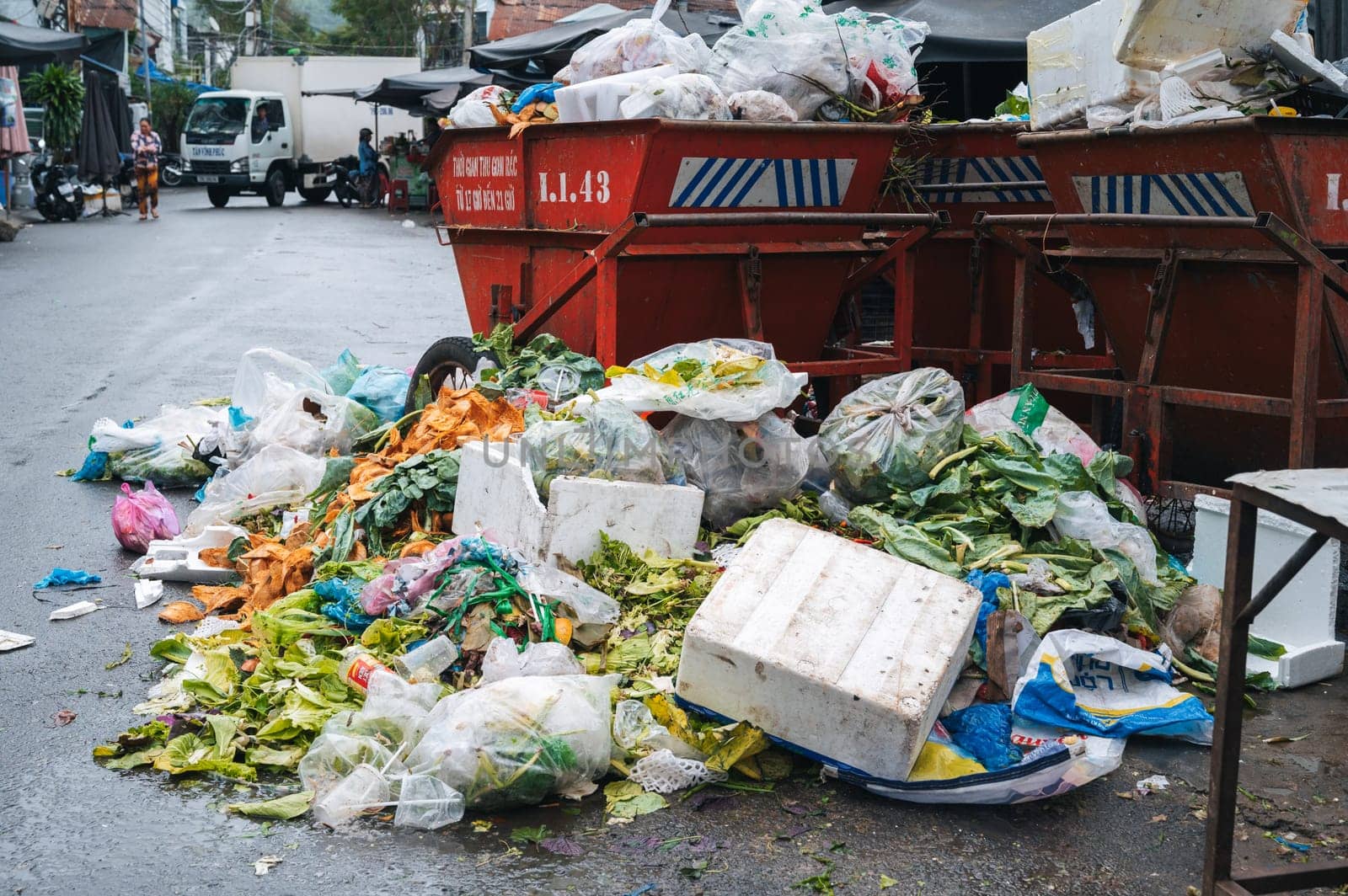 Piles of junk, trash and litter, near to overloaded dumpsters. Plastic bags, cardboard boxes and organic waste. Nha Trang, Vietnam - December 13, 2024