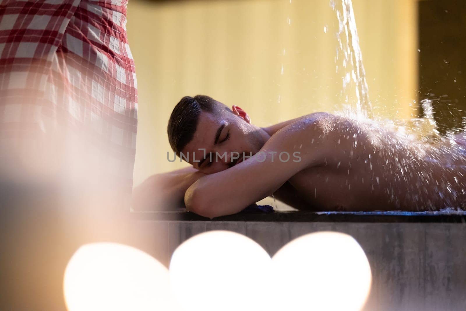 Water Treatment in Turkish Hammam.Man receiving water therapy inside a traditional Turkish hammam with ornate details.