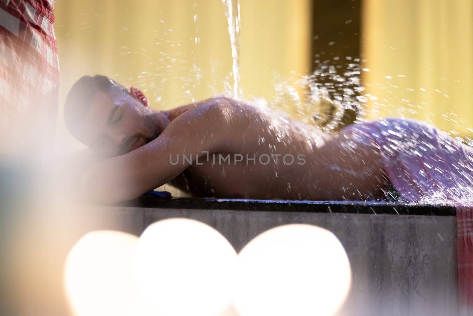 Water Treatment in Turkish Hammam.Man receiving water therapy inside a traditional Turkish hammam with ornate details.