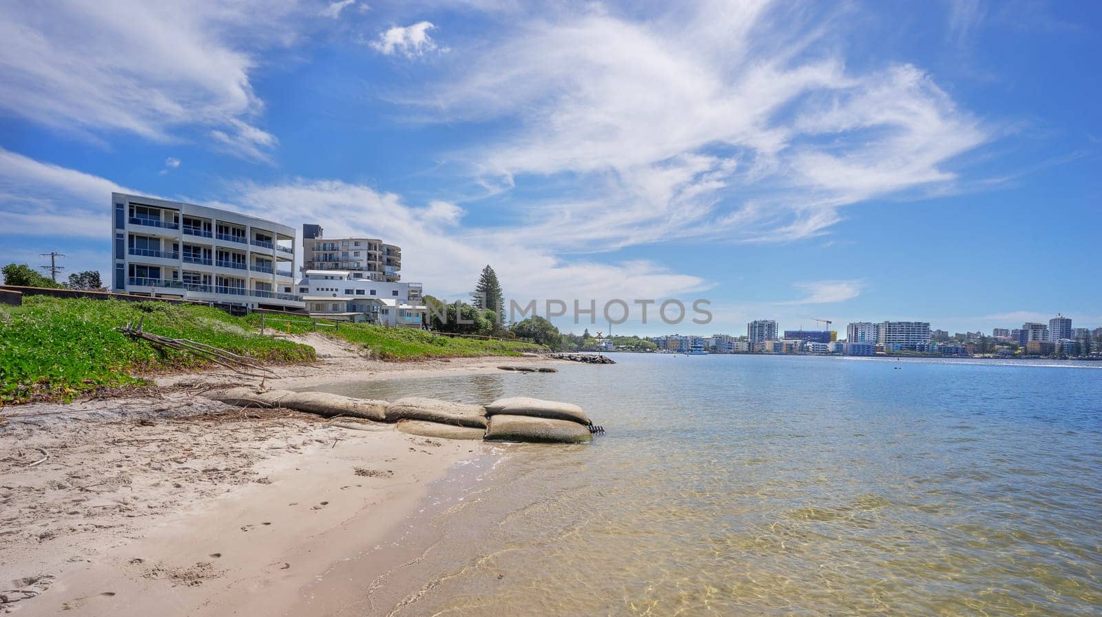 View of  calm waters of Pumicestone Passage at Golden Beach looking towards the highrise buildings of Caloundra on the Sunshine Coast Queensland Australia