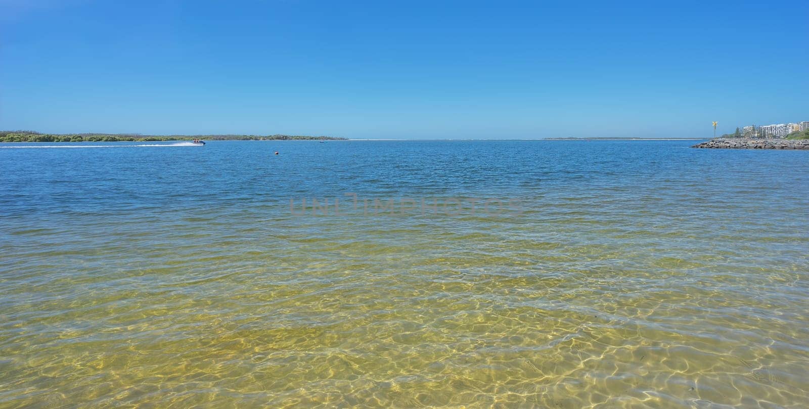 Looking across the spanse of calm water from Golden Beach to Bribie Island showing the new bar crossing that has been formed by cyclonic weather
