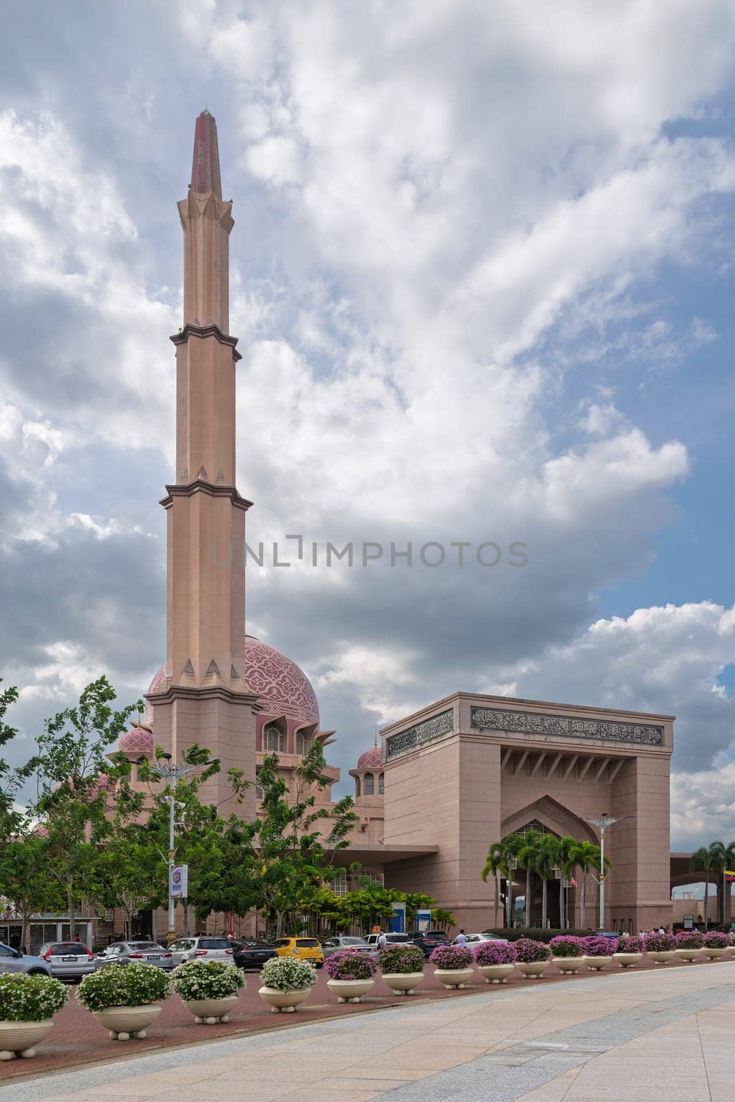 Putrajaya, Malaysia - February 20, 2025: Putra Mosque, Exterior view of the pink mosque with minaret and dome under cloudy sky