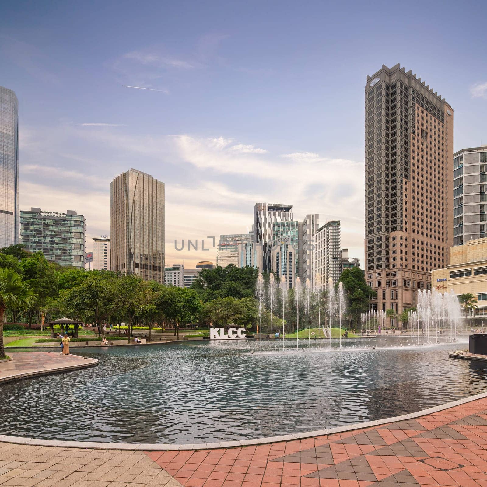 Kuala Lumpur, Malaysia - Feb. 17, 2025: Dusk at KLCC Park: fountains, KLCC sign, Suria KLCC, Mandarin Oriental, and Grand Hyatt hotel