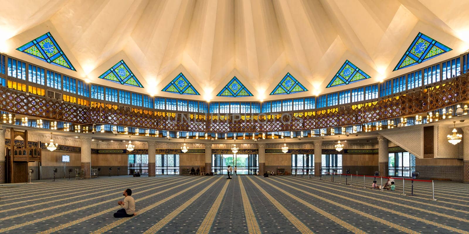 Masjid Negara, or National Mosque prayer hall, Kuala Lumpur, Malaysia. Iconic star-shaped dome, vibrant stained glass with calligraphy, Islamic geometric patterns