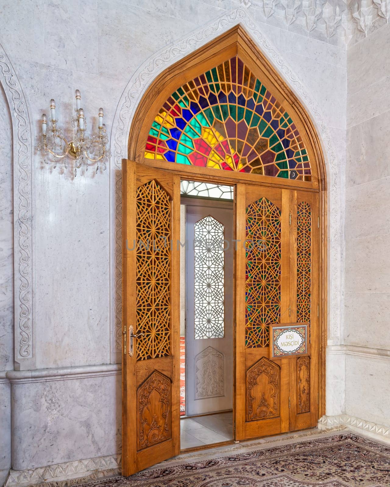 Vibrant stained glass decorates a wooden door at Bibi-Heybat Mosque in Baku, Azerbaijan, showcasing rich cultural heritage and architectural elegance