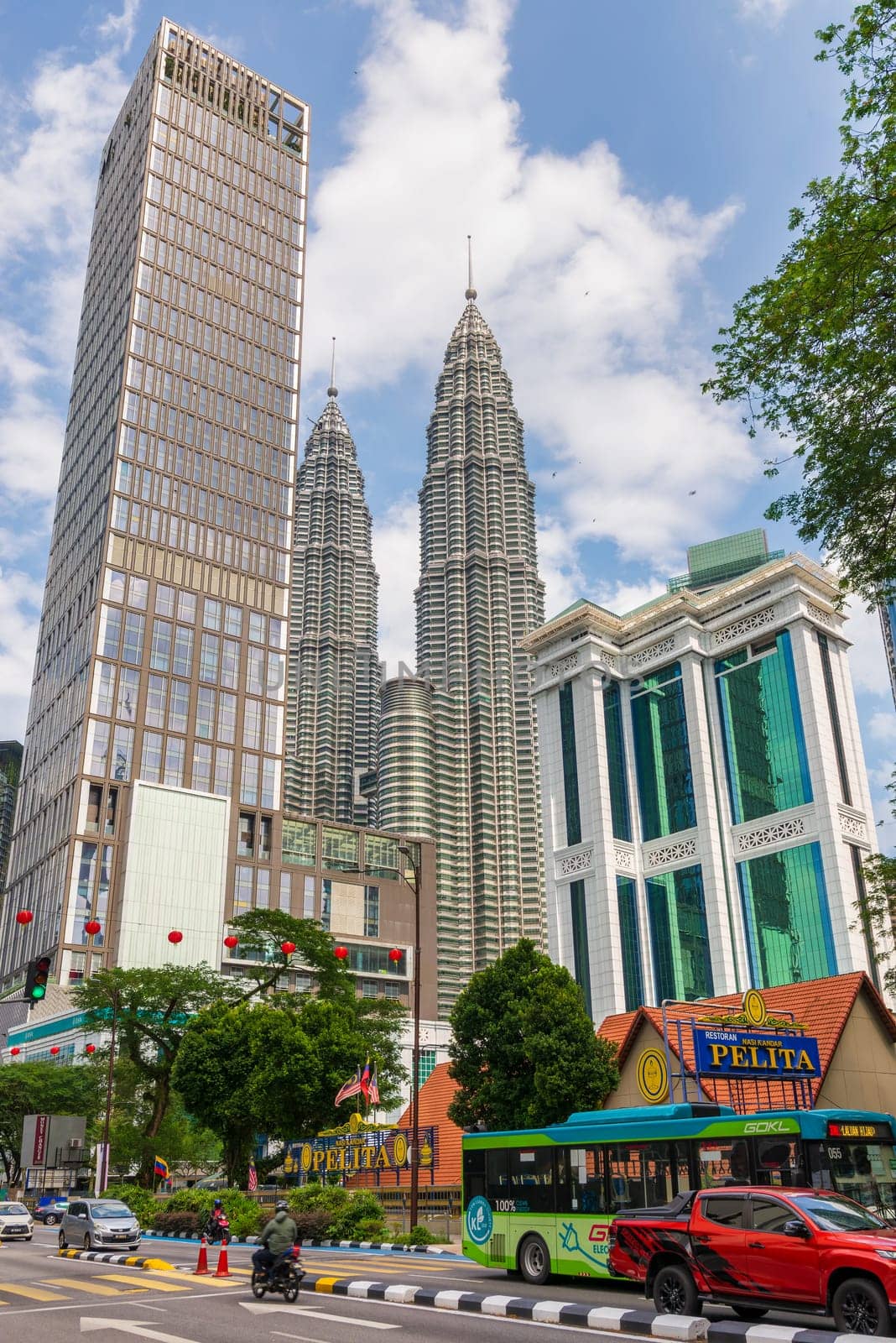 Kuala Lumpur, Malaysia - February 17, 2025: In this bustling metropolis, the towering Petronas Towers stand proudly amidst the urban skyline, harmoniously juxtaposed with the contemporary Maxis Tower