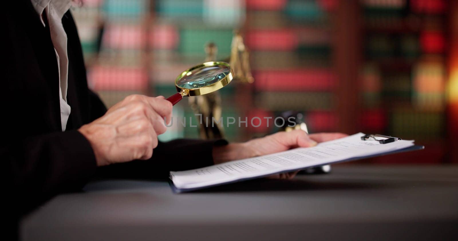 Female Judge Examining Legal Document With Magnifying Glass In Courtroom.