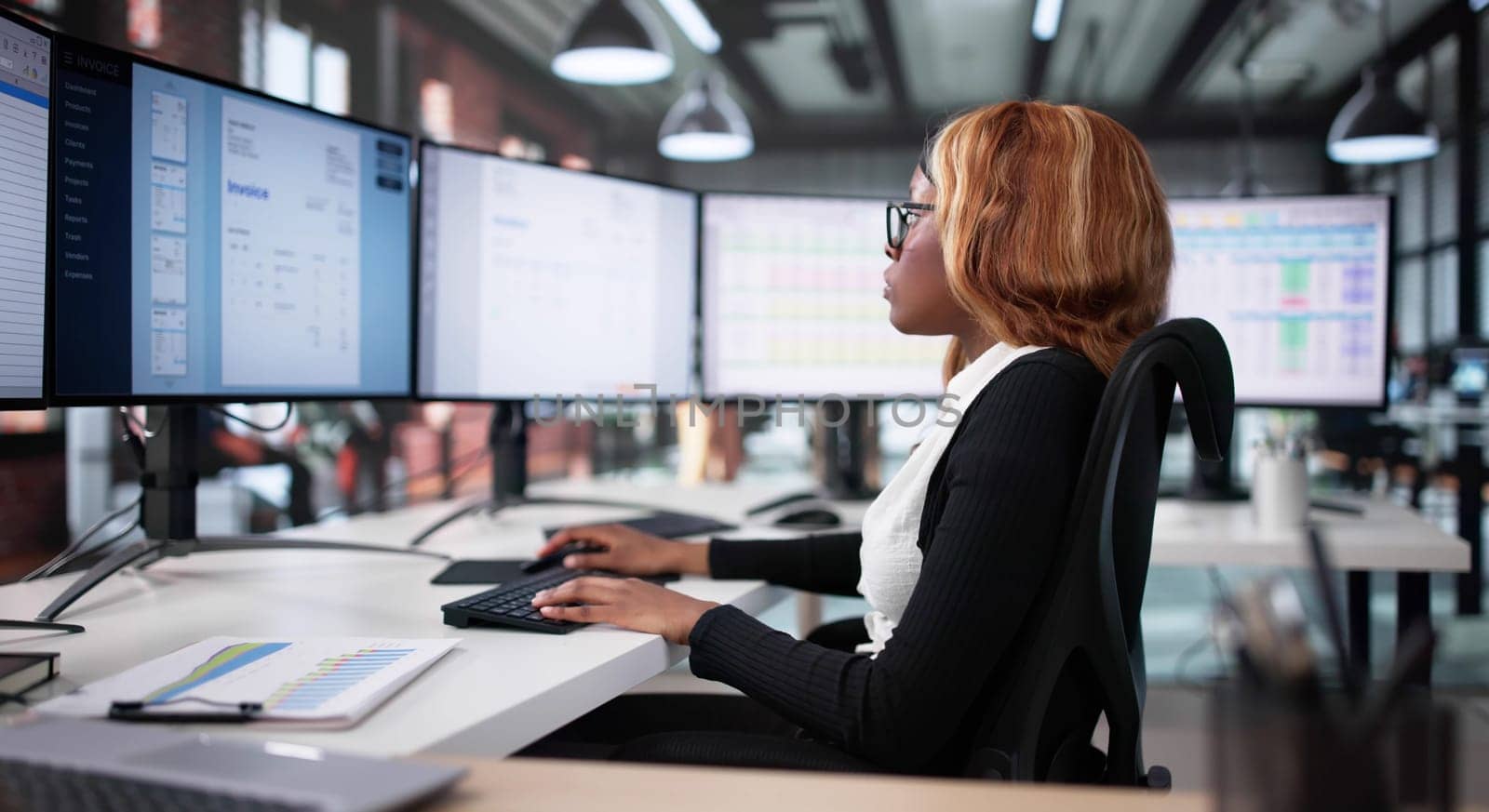 African American Woman Using Computer Monitor For Business Invoice Viewing. Young Black Woman Checking