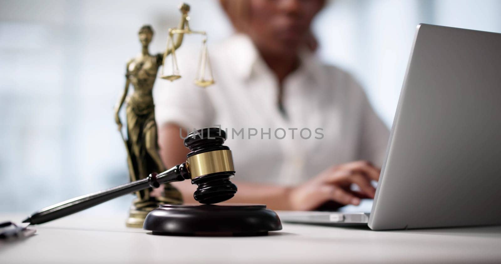 An African American Female Lawyer Typing On Her Laptop In Court.