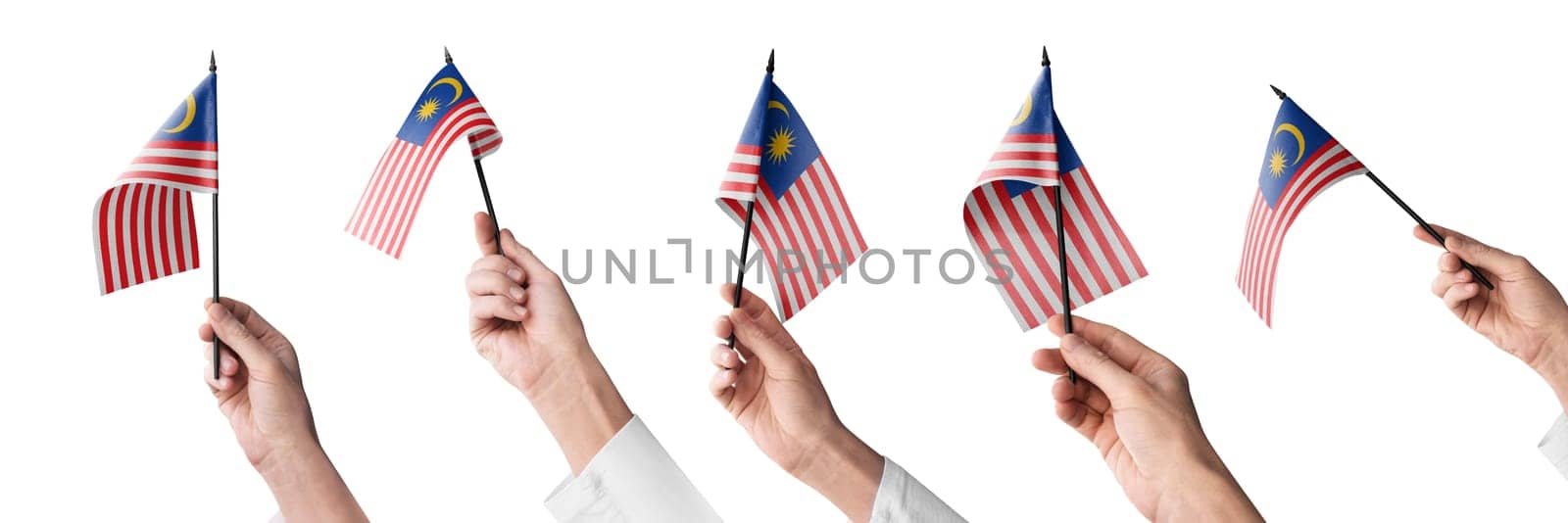 The Malaysia flag in hand in different angles on a white background.