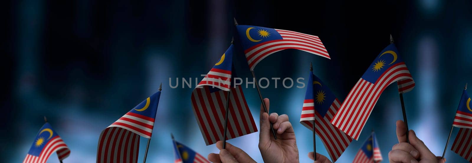 Malaysia flags in their hands on a blurred urban background. The photo illustration was created without the use of artificial intelligence, only using Photoshop.