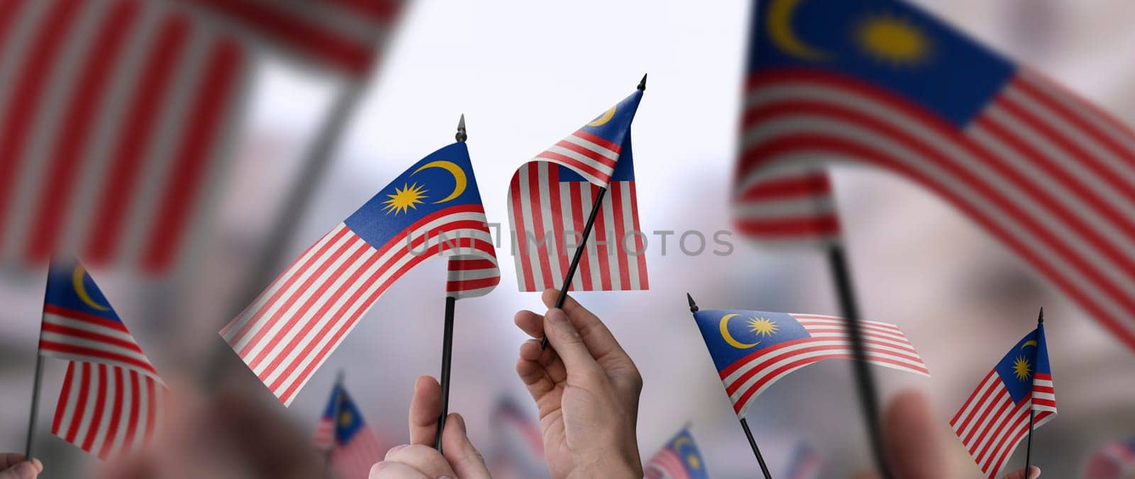 Malaysia flags in their hands on a blurred urban background. The photo illustration was created without the use of artificial intelligence, only using Photoshop.