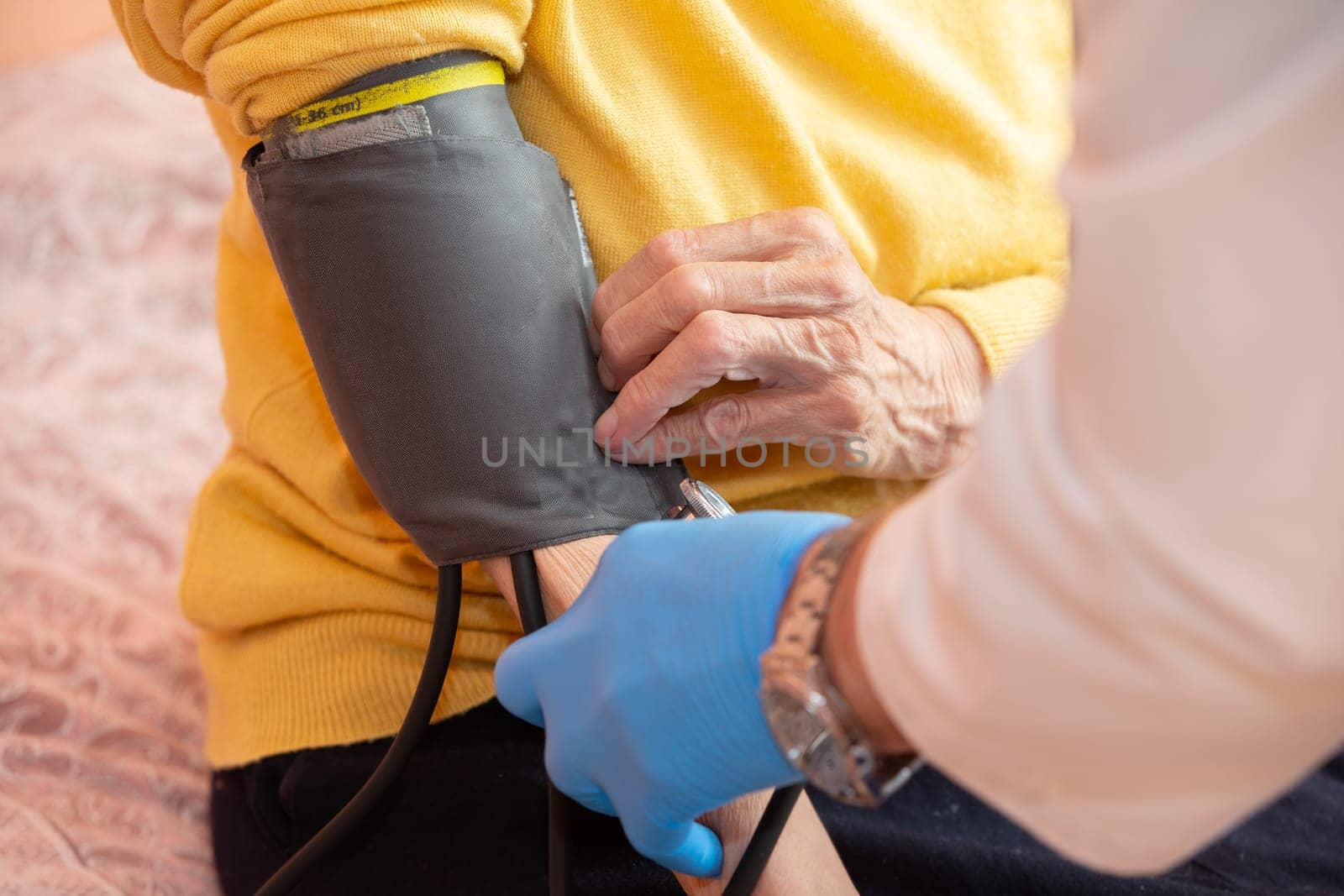 A doctor using a sphygmomanometer with a stethoscope revealed arterial hypertension in a patient in the hospital.