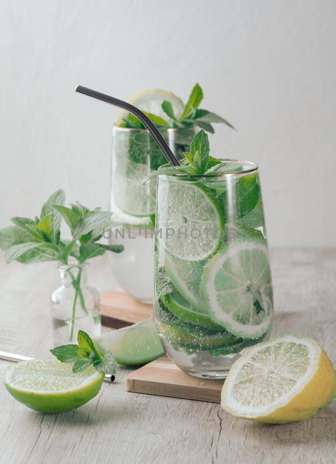 Summer drink with lime and mint. Cold drink, non-alcoholic mojito or lemonade, garnished with fresh mint sprigs and citrus slices. 