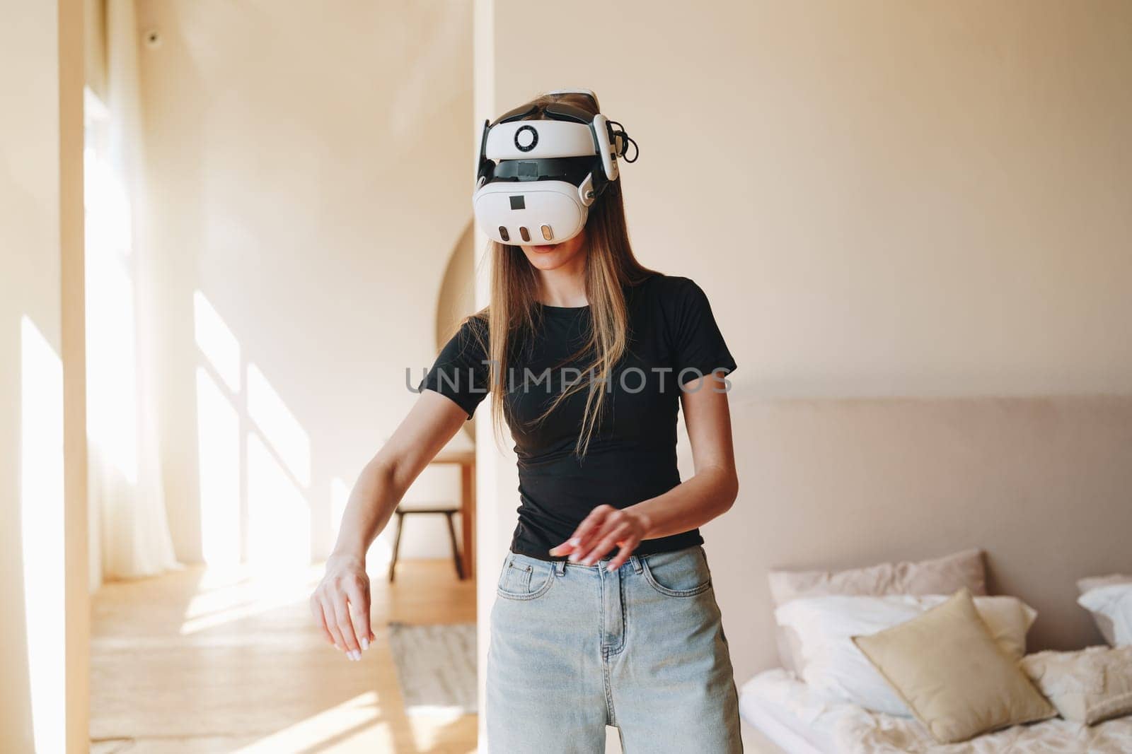 A young woman is engaged in a virtual reality experience in a stylish living room filled with natural light.