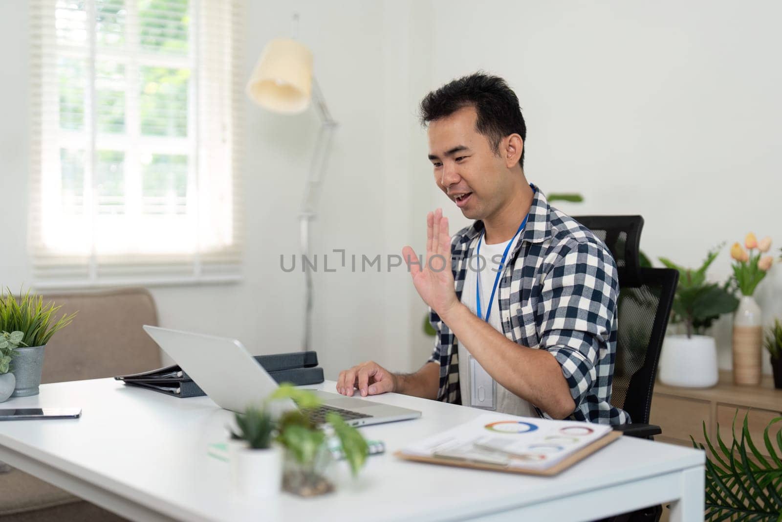 A young professional examines documents at his desk, emphasizing organization and planning in a stylish remote workspace.