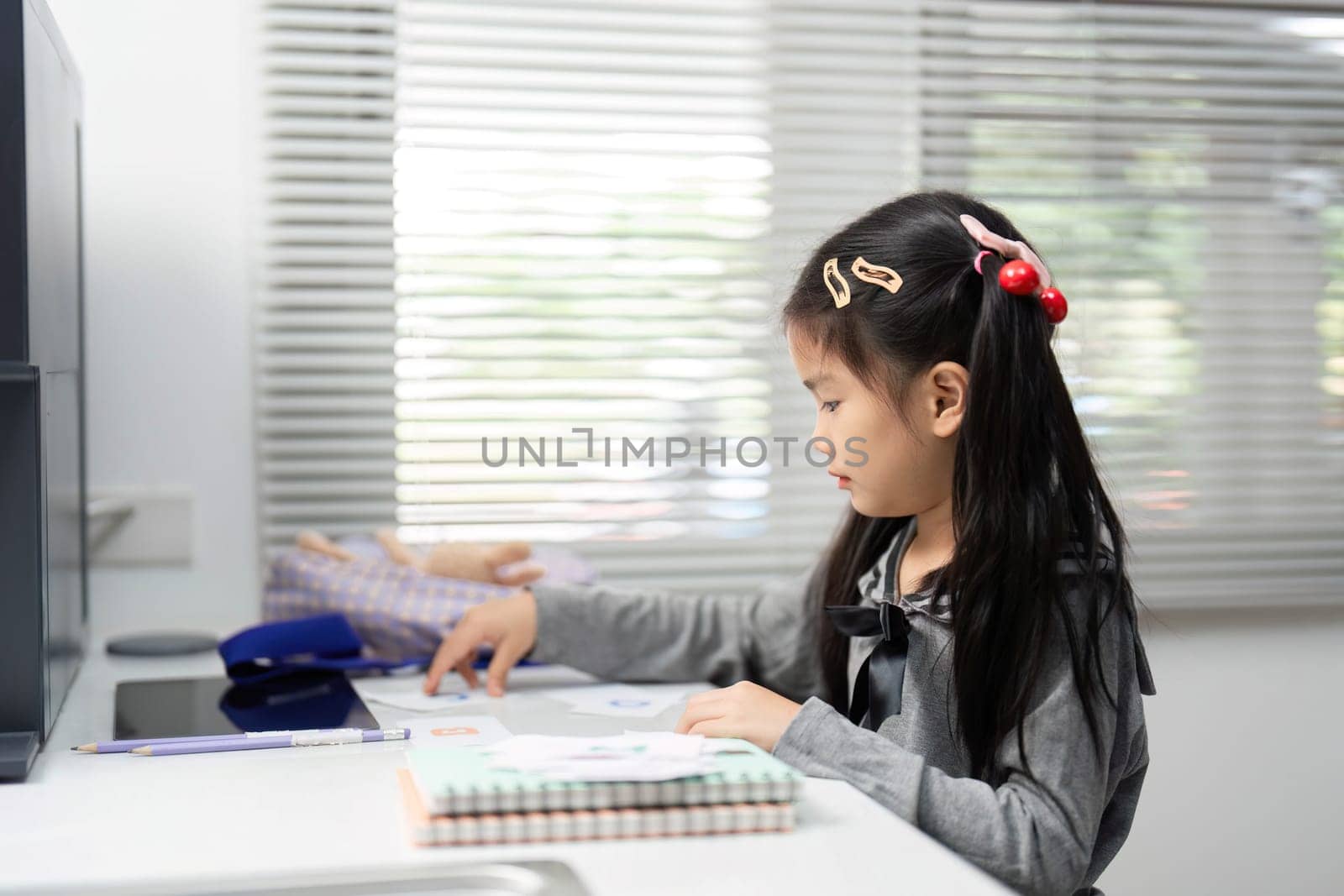 A young girl concentrates on her creative project, exploring her artistic side in a bright, inviting home workspace.