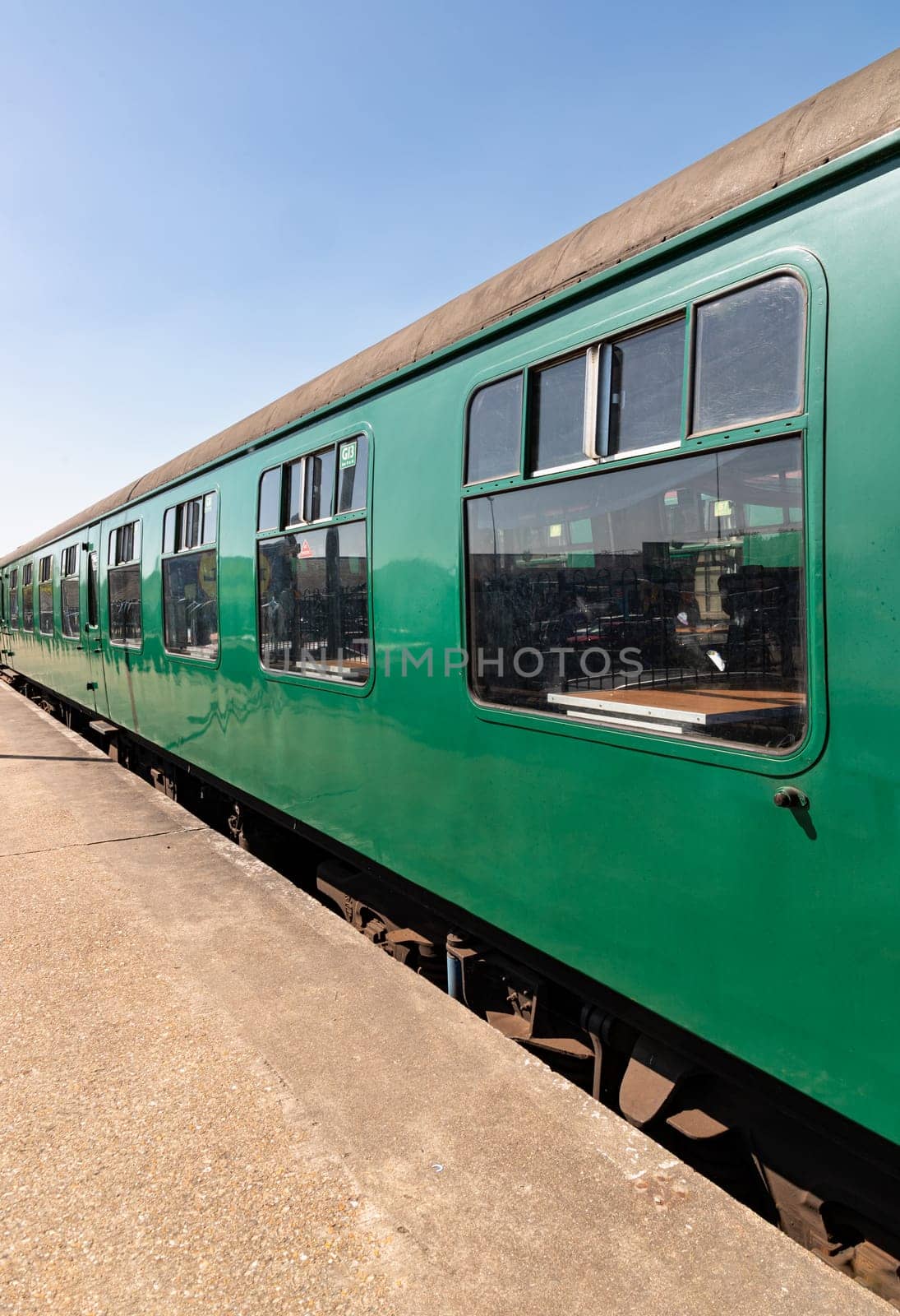 Royal Tunbridge Wells, UK - Apr 29, 2025 - Perspective view of The empty passenger green railway carriages at Tunbridge Wells railway station. use it as your Wallpaper, Poster and Space for text, Selective focus.