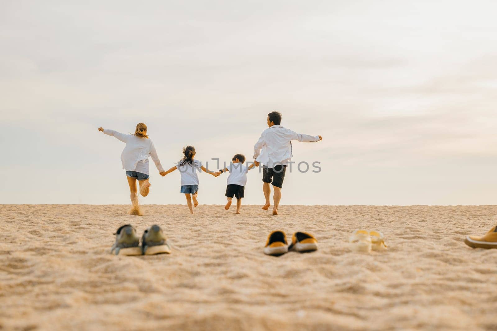 Father, mother and kids take off shoes run on sand beach, Back view of family parents with children fun holding hands together running to beach in holiday, Travel, active lifestyle, Happy family day