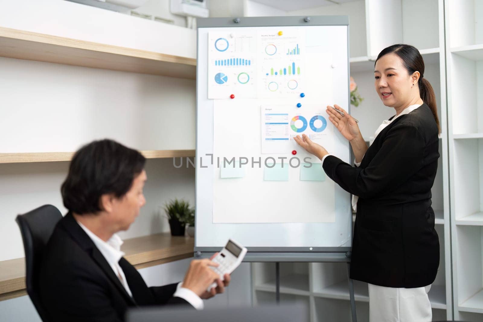 A business consultant explains key performance indicators to a male client during a strategy session.