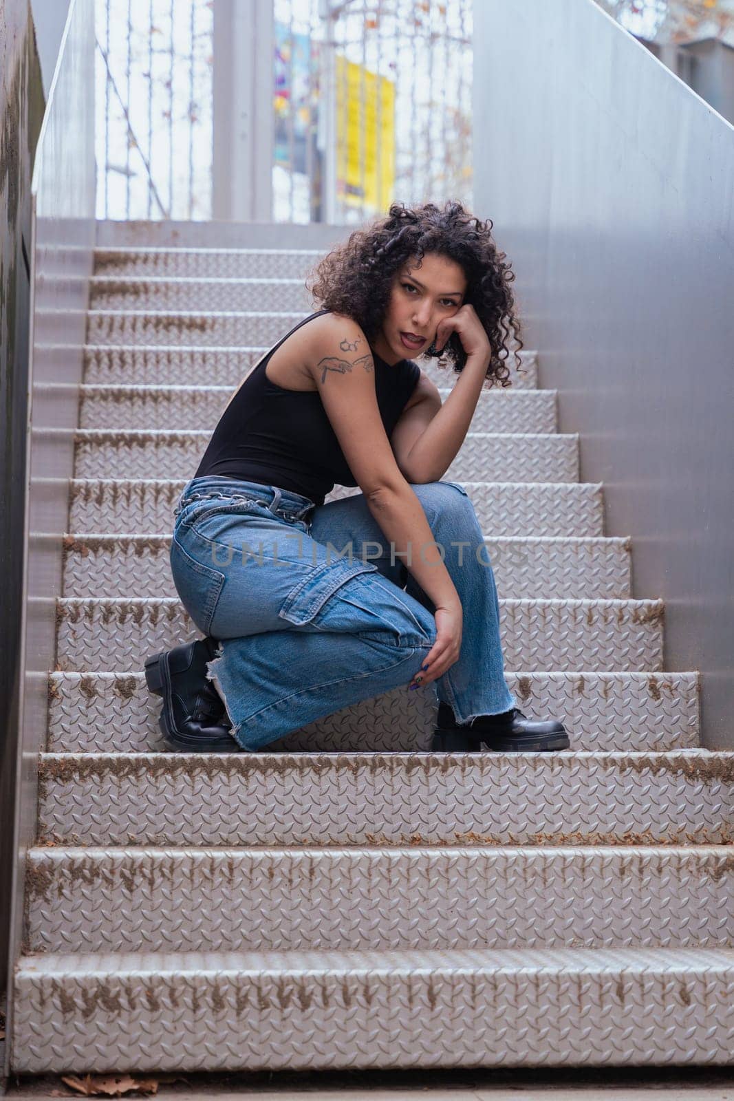 African American woman dancing in a creative pose between benches in an urban setting. he wears casual clothes and shows balance,strength, and expression. Concept of movement, art,and freedom.Vertical