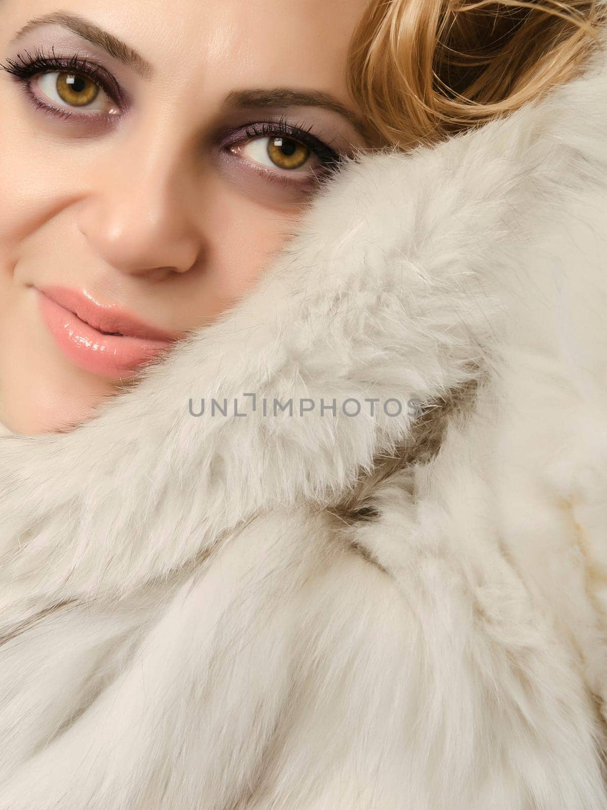 Close up of a beautiful women wearing a fur coat and looking at camera