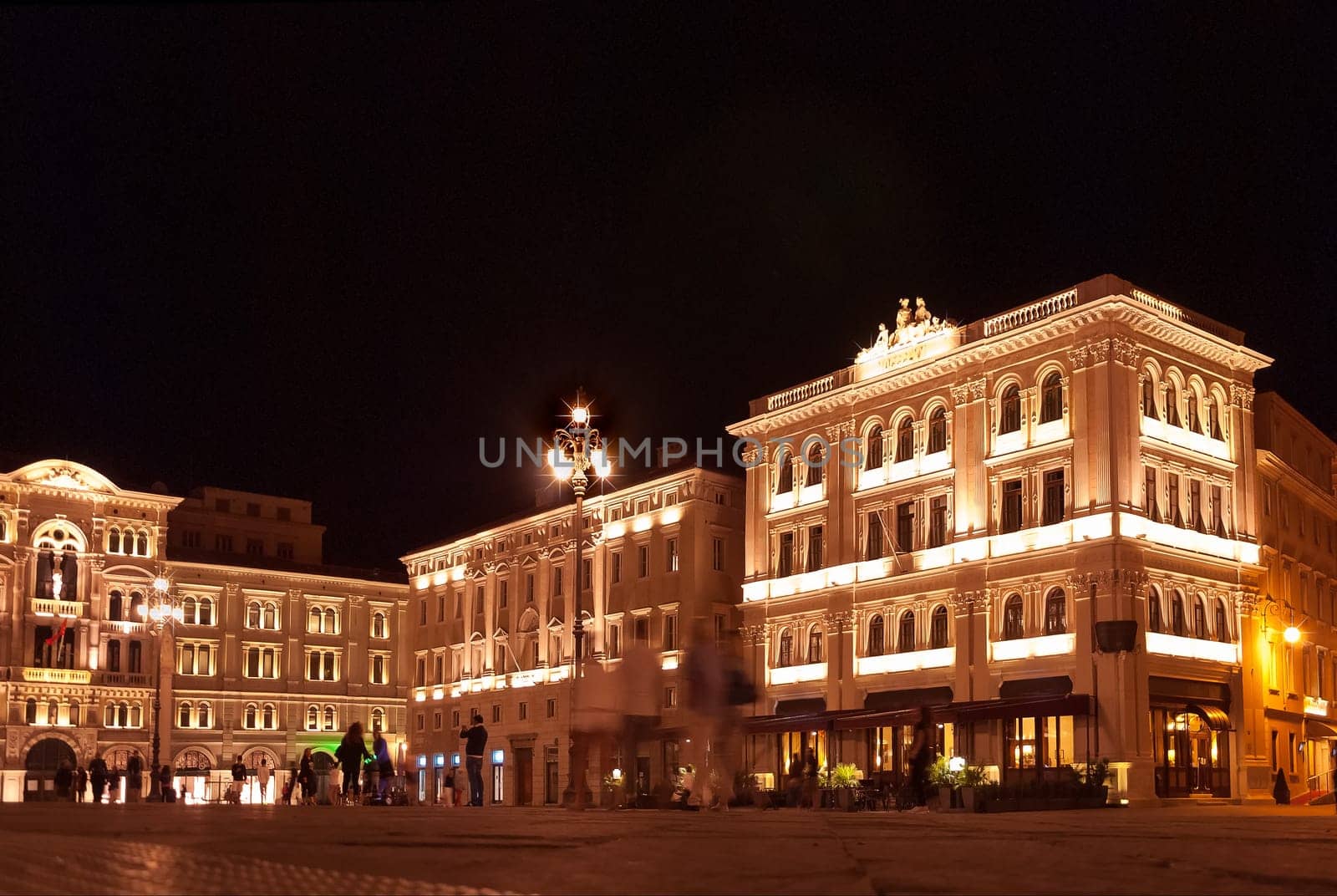 Unity square or Piazza dell'Unita in Trieste, Italy, with and municipality palace or Palazzo del Municipio after sunset. Biggest city square in Europe open to seafront with its city lights on