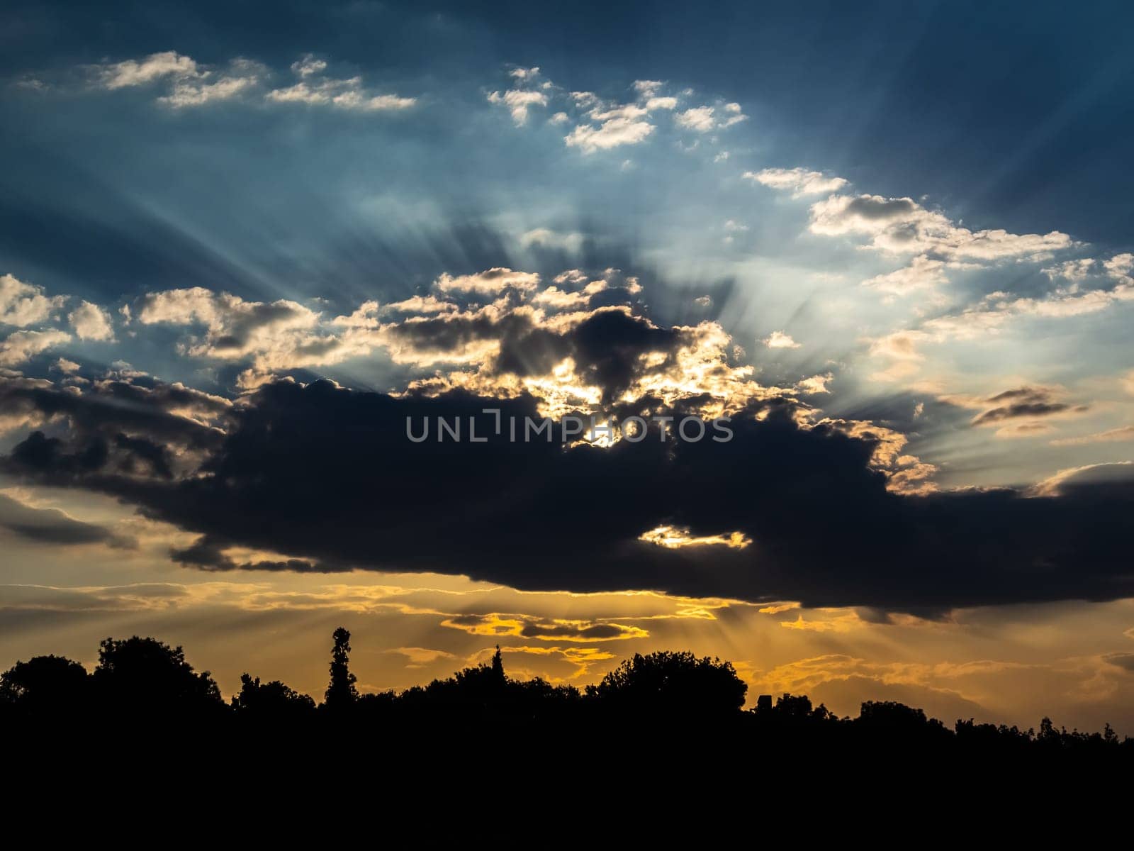 Dramatic sky with clouds on sunset and city silhouette in bottom