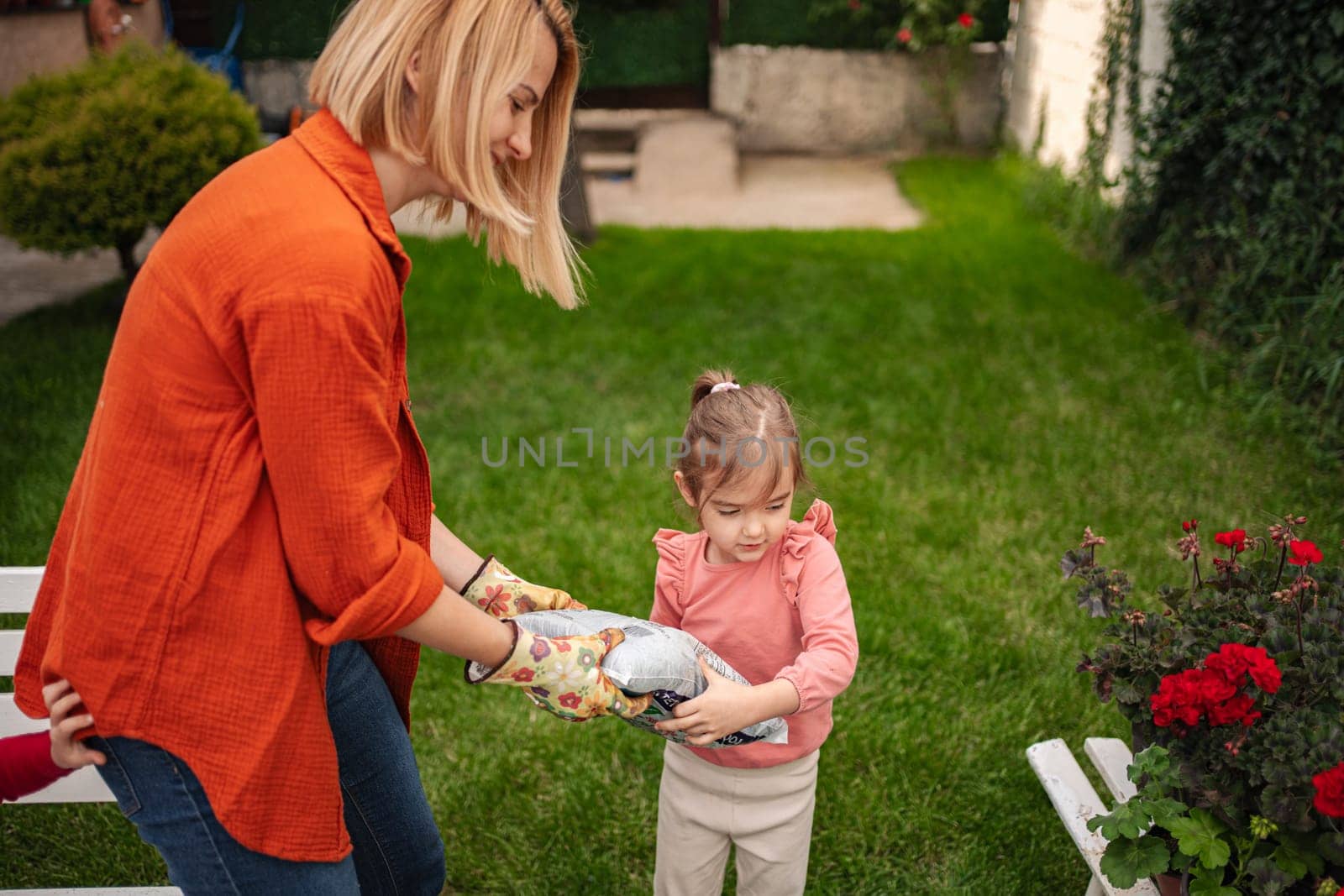 A mother shares a special gardening moment with her daughter.