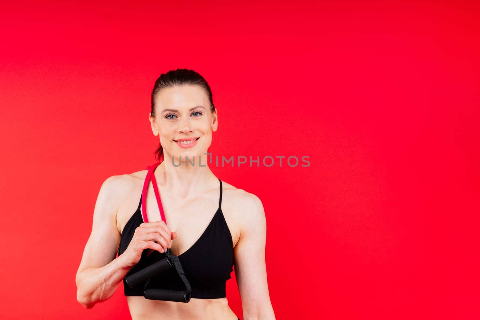 Athletic female performs exercises using resistance band. Strength and motivation
