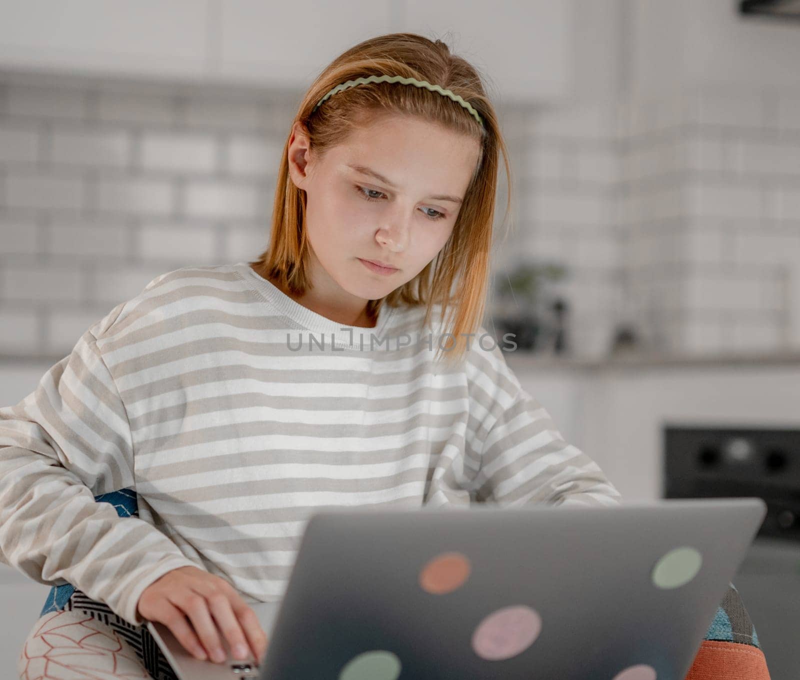 Cute Little Girl Uses A Laptop At Home To Surf The Internet, Watch Movies, And Feed On Social Media