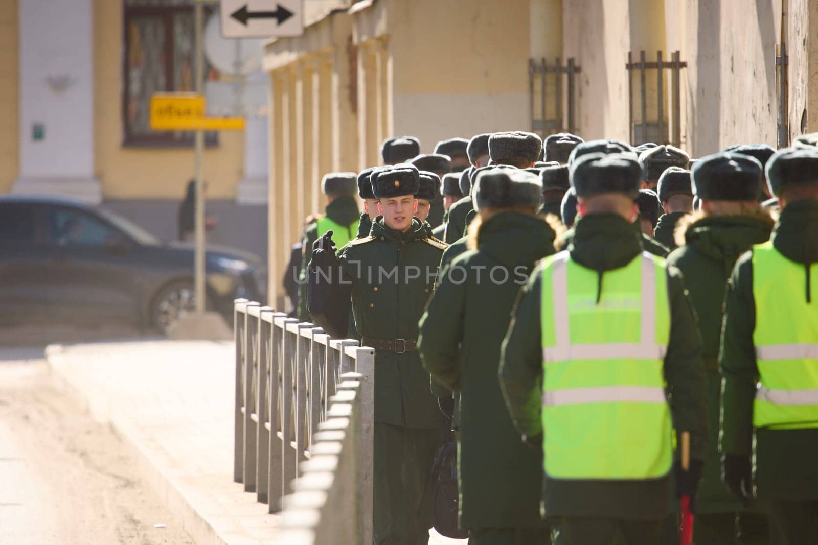 Russia, St.Petersburg, 26 March 2025: a column of cadets of military forces walk along the fence and gates with the symbols of the armed forces. High quality photo