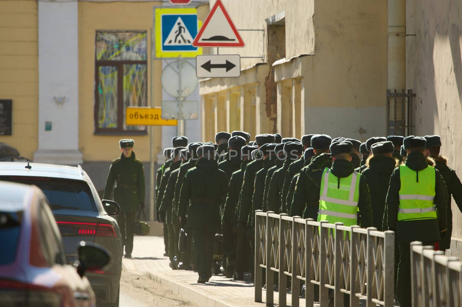 Russia, St.Petersburg, 26 March 2025: a column of cadets of military forces walk along the fence and gates with the symbols of the armed forces. High quality photo